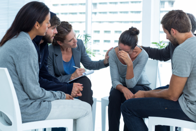 group of people comforting woman